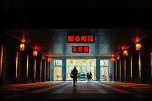 《山那边的信》走廊场景，一盏壁灯照亮三个时空的门框